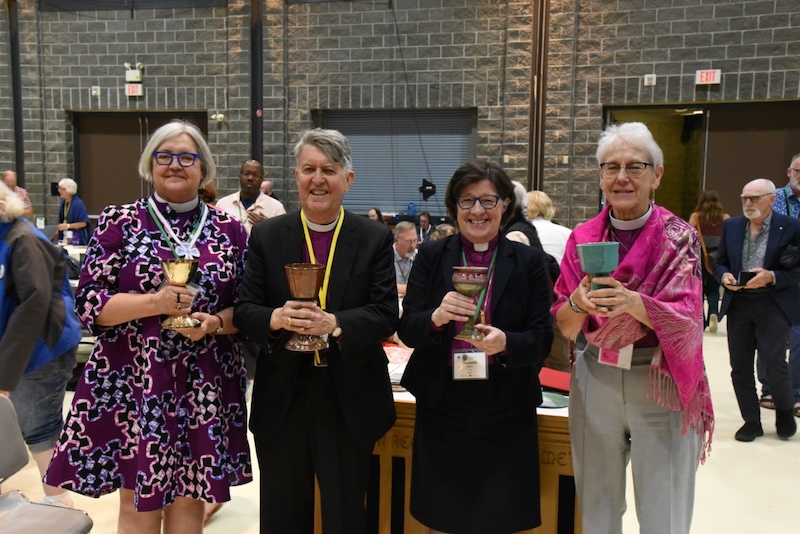 Four bishops stand holding chalices